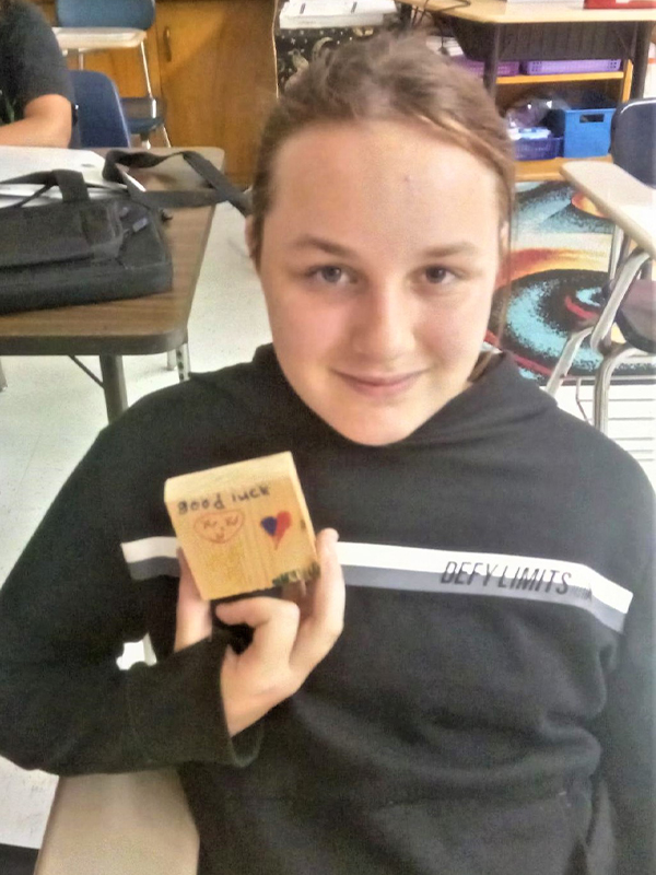 A student holding a drawn rosette corner block.