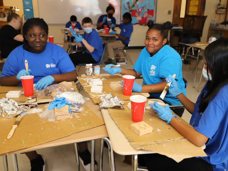 Students painting on rosette corner blocks.