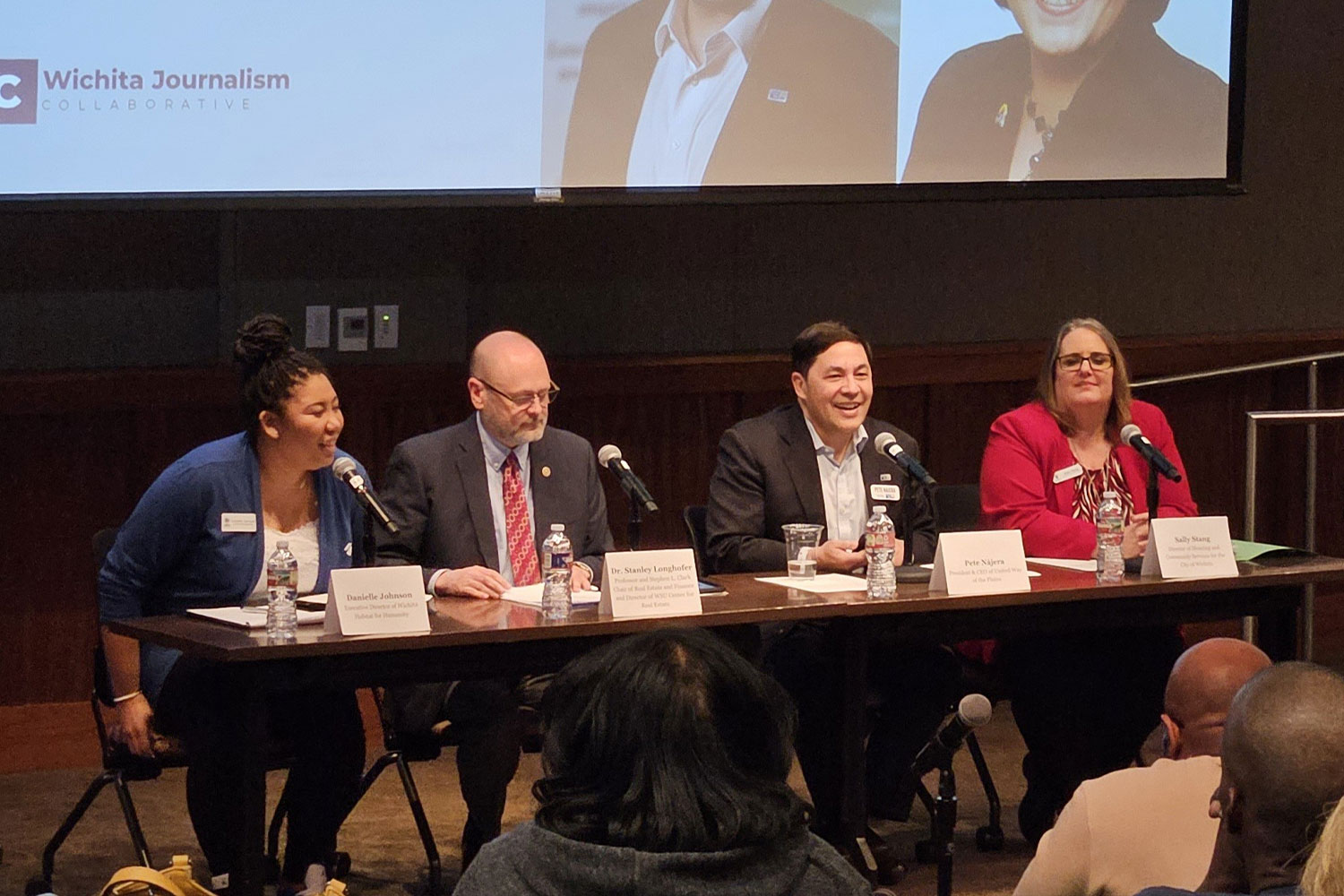 A group of panelists presenting at a community listening session.