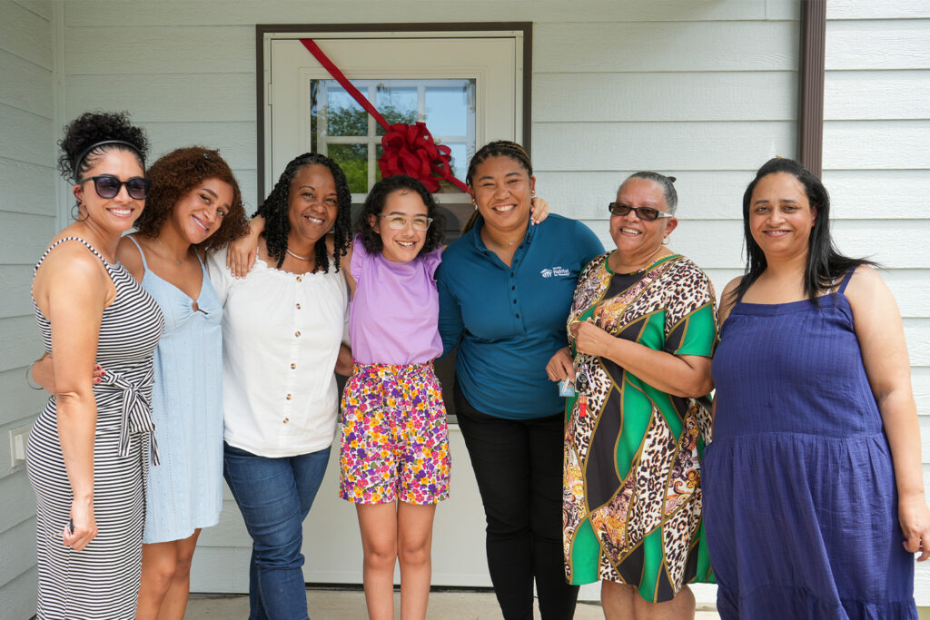 Family partner Lovetta receiving her keys to her home and surrounded by her family.