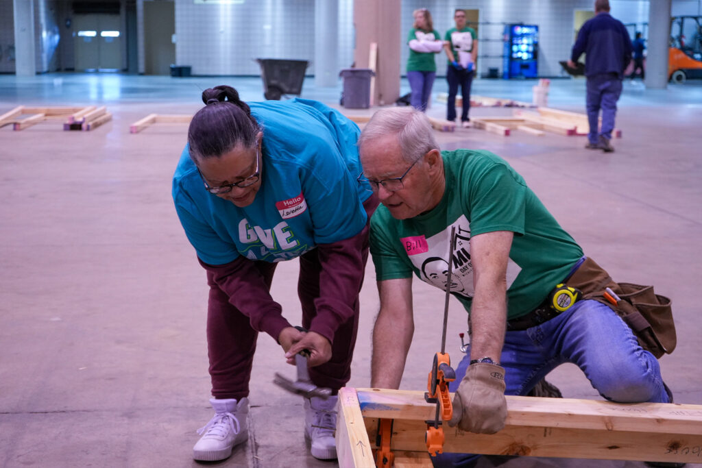 Family partner Lovetta using a hammer with a volunteer at the MLK Day of Service event.