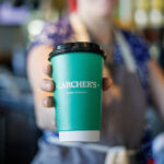 A cup of coffee with Larcher's branding.