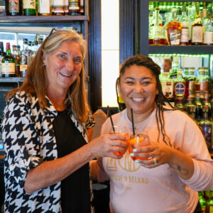 Ann Fox and Danielle Johnson clinking their glass of sangria together.