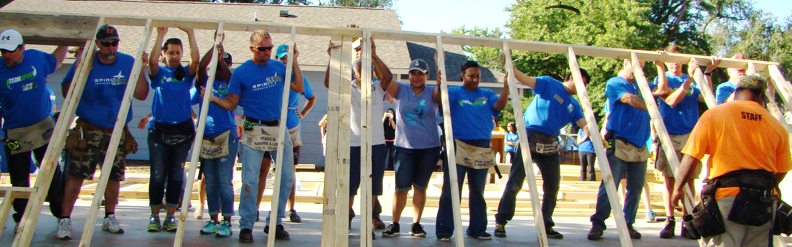 Spirit AeroSystems volunteers raising up a wall.