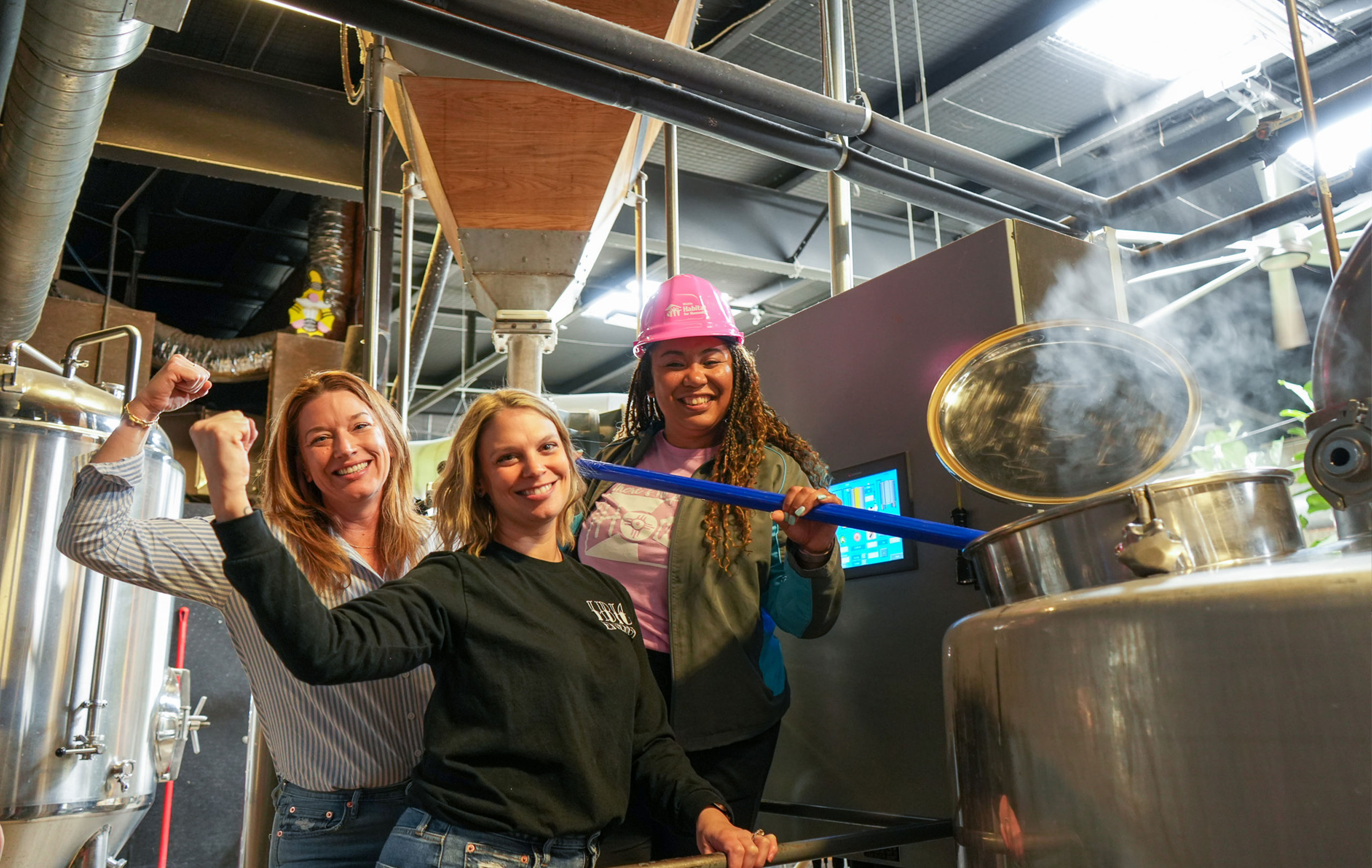 Participants standing next to a brew machine.