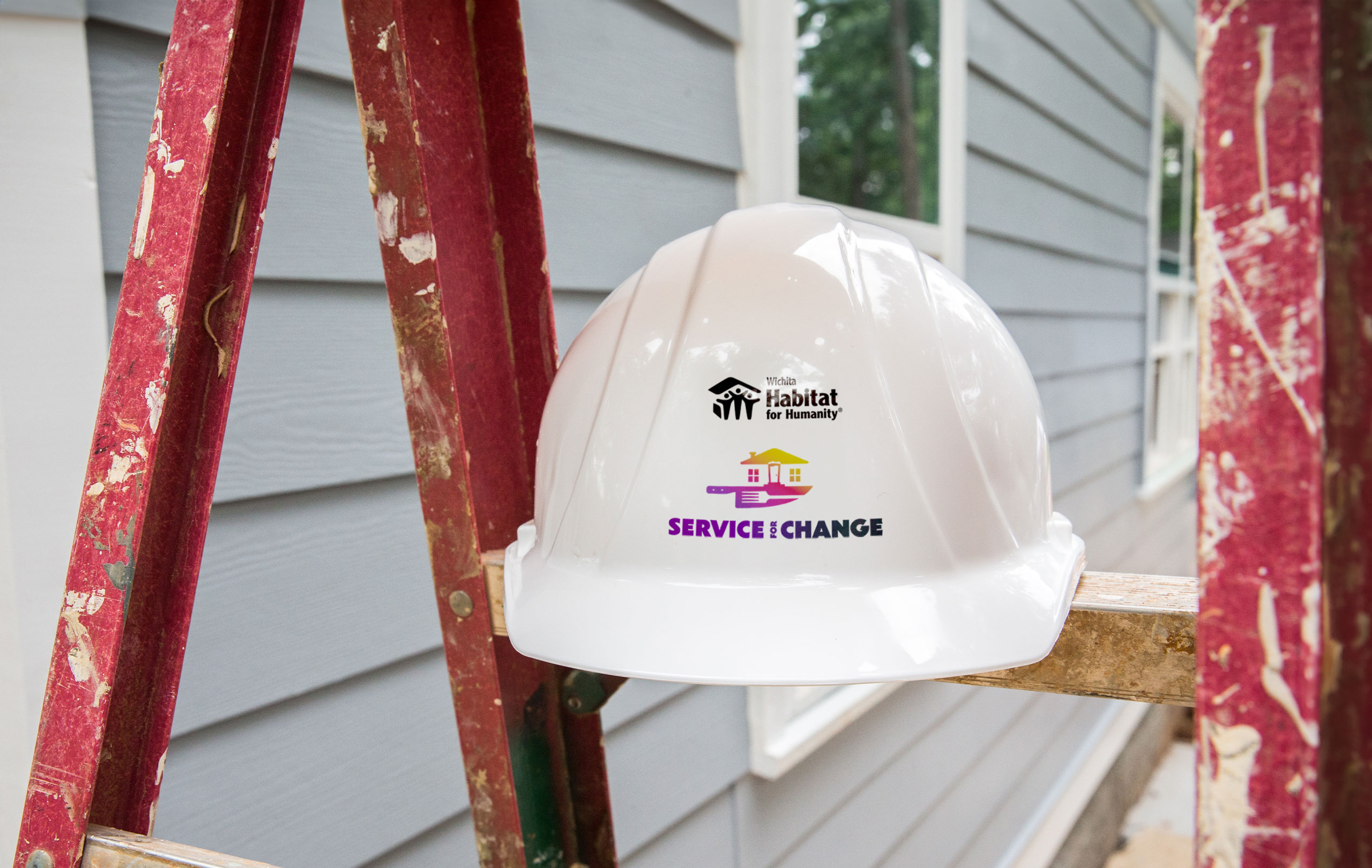 A hard hat sitting on a ladder.