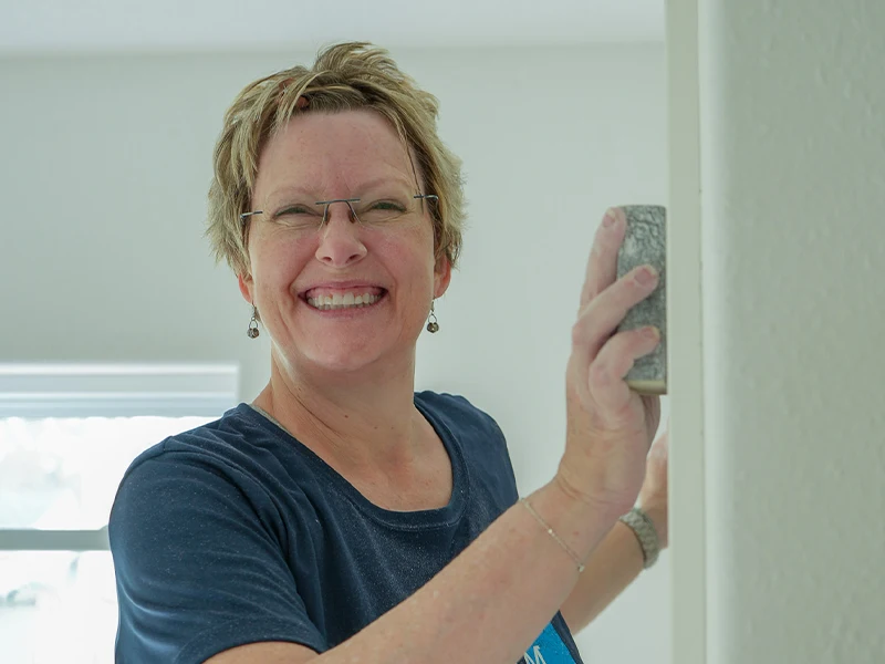 A volunteer scrubbing the wall during painting.