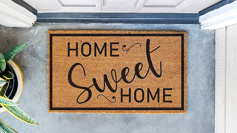 A home sweet home doormat in front of a door.