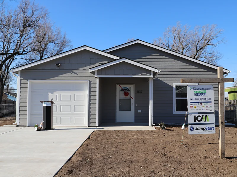 A small, single-story gray house with a garage.