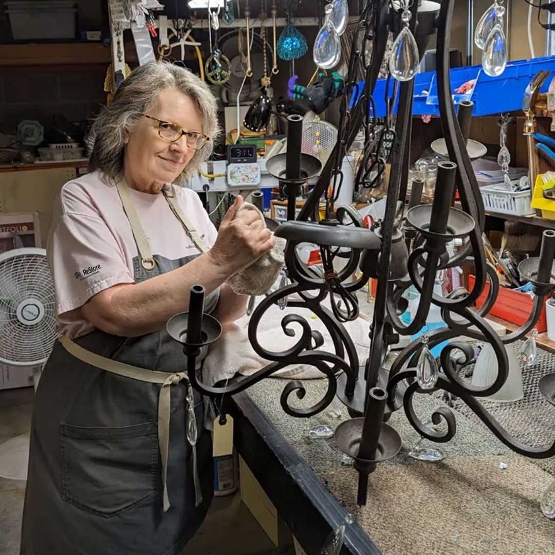 An employee cleaning a chandelier.