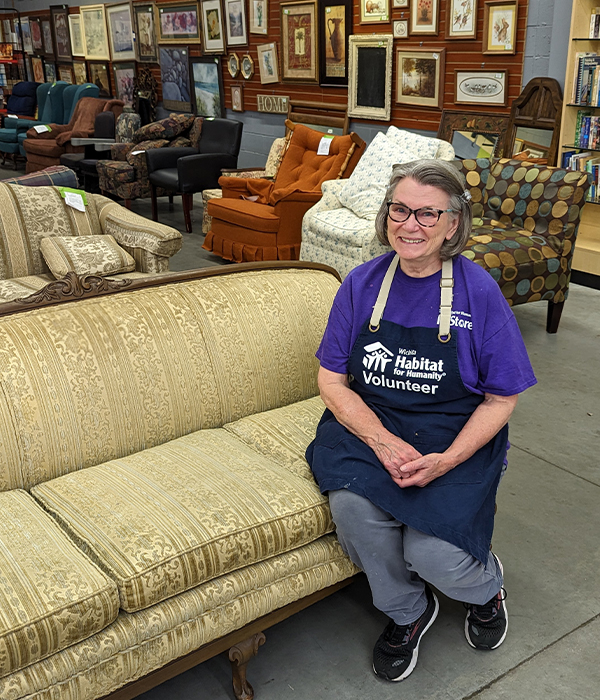 Core volunteer Connie Jason sitting on a couch.