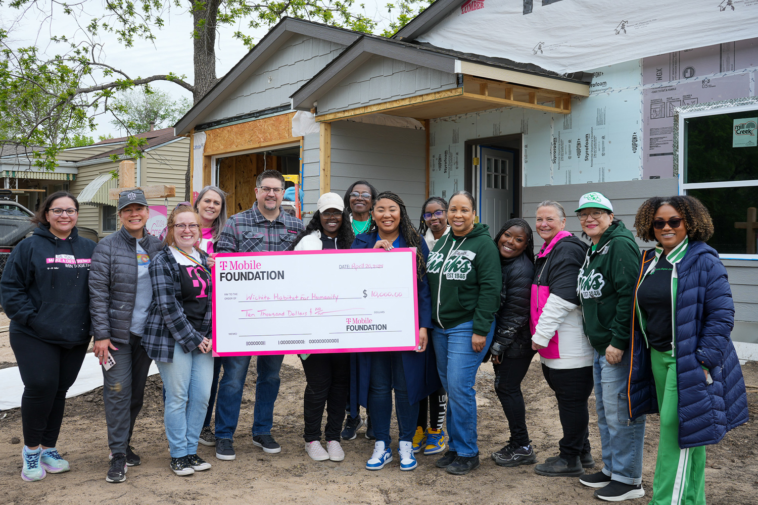 Representatives of T-Mobile, Wichita Habitat, and volunteers holding a $10,000 check.
